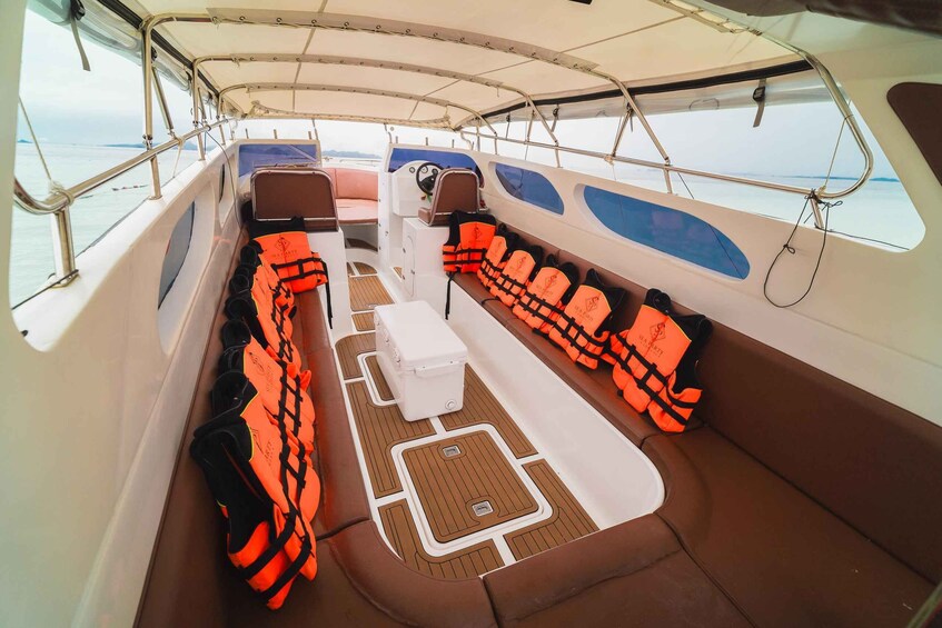 A boat's interior with seating, life jackets, and a steering wheel. 3