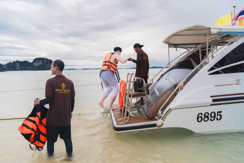 A boat with the number 6895, people boarding, and a lifebuoy on the deck. 5
