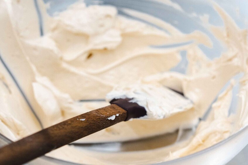 A mixing bowl with a wooden spoon and a dollop of chocolate on the side. 2