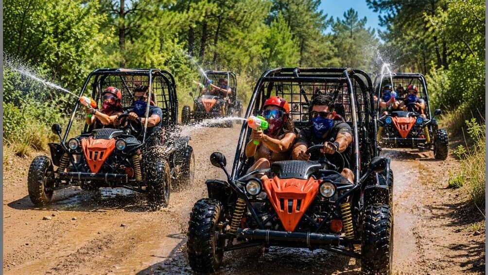 Off-road vehicles on a muddy trail with passengers spraying water. 4