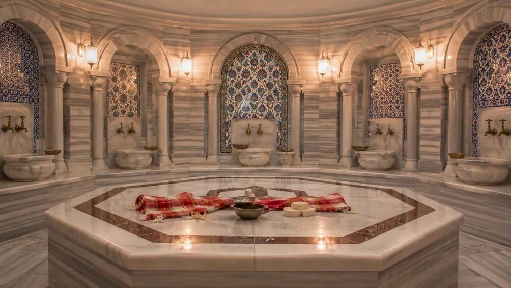 A luxurious interior with a central marble fountain, ornate arches, and patterned tile work. 5