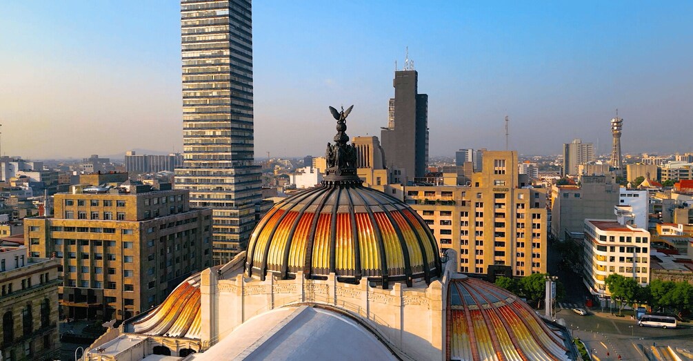 A cityscape with a prominent dome featuring a colorful mosaic, surrounded by modern high-rise buildings. 5
