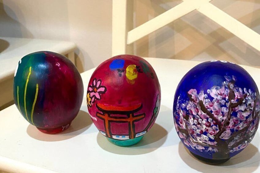 Three painted glass balls with floral and geometric designs. 2