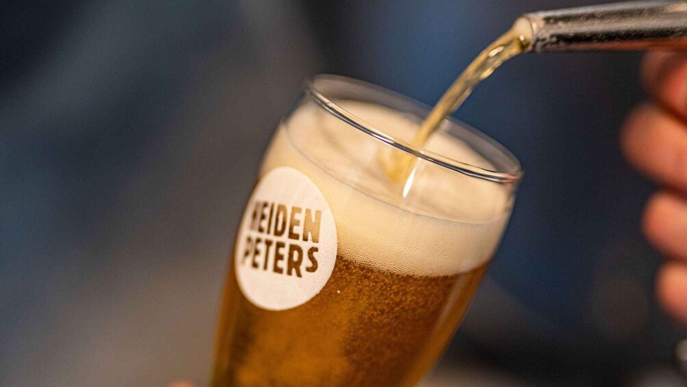 A glass with a label reading 'NEIDEN PETERS' being filled with a liquid. 1