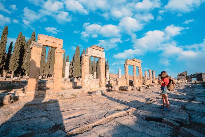 Ancient ruins with columns and stone structures under a clear sky. 4