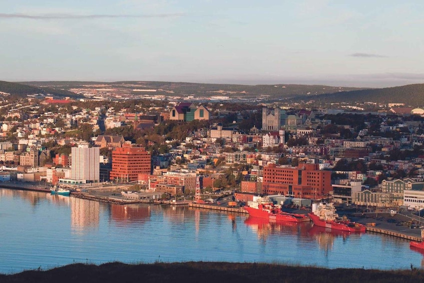 A coastal cityscape with a prominent red ship docked at the harbor, surrounded by a mix of historic and modern buildings. 1