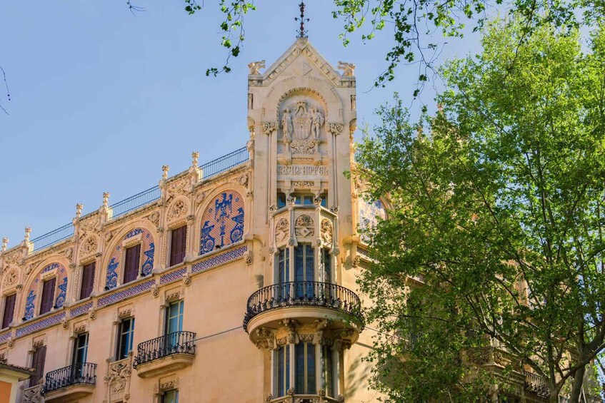 A historic building with ornate facades and blue tile accents, featuring a prominent clock tower. 5