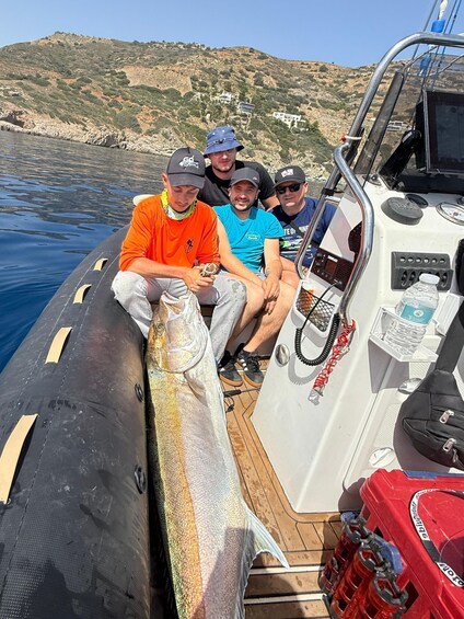 A group of people on a boat with a large fish. 1