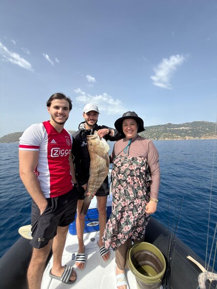 Three people on a boat with a fish, water, and a distant shoreline. 3
