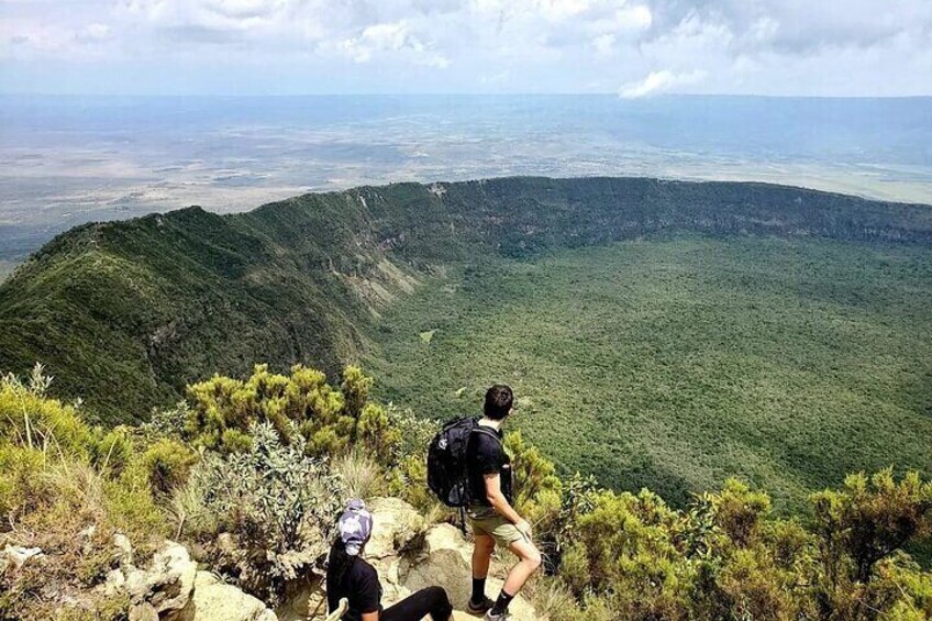 Two hikers on a mountain trail with a view of a valley and distant mountains. 3