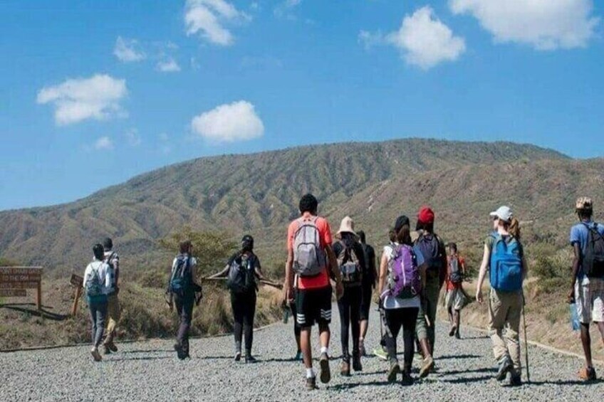 A group of hikers on a gravel path with a mountainous backdrop. 5