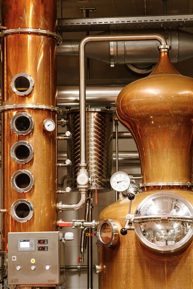 A copper distillation apparatus with gauges and valves, part of a distillation system. 3