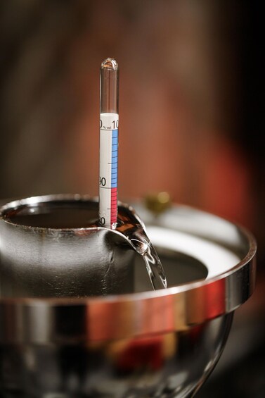 A thermometer in a metallic bowl with a liquid. 4