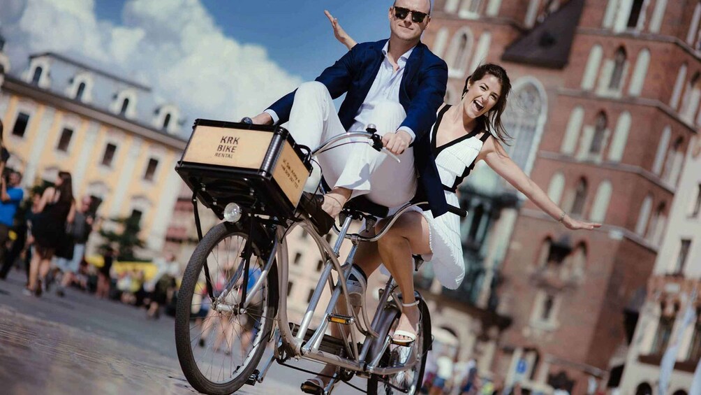 Henkilö ajaa polkupyörällä, ja pyörän etuosaan on kiinnitetty laatikko, jossa lukee: ”KPK BIKE RENTAL”. 1