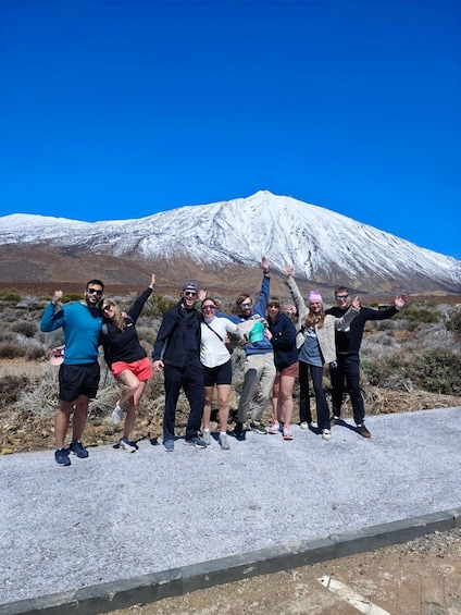 A group of people standing on a road with a snow-capped mountain in the background. 4