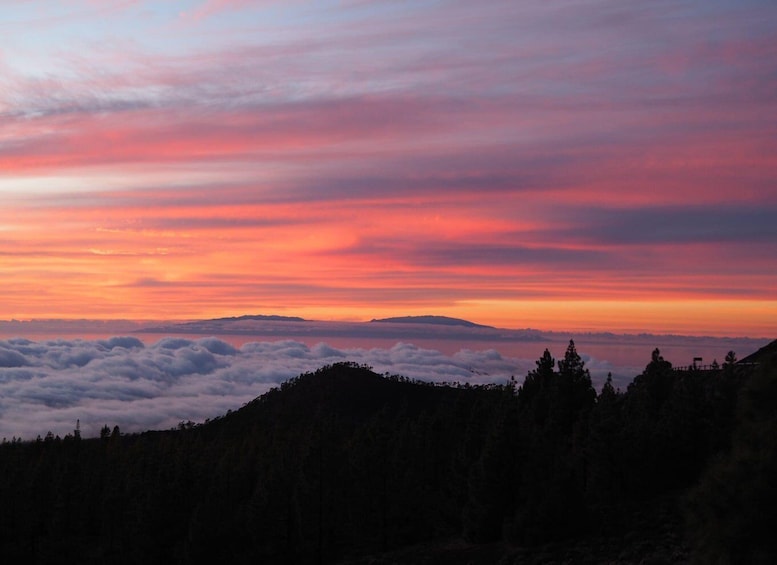 A sunset over a mountain range with clouds below. 5