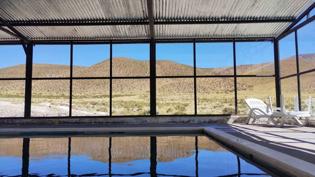 An indoor swimming pool with a view of desert hills. 3