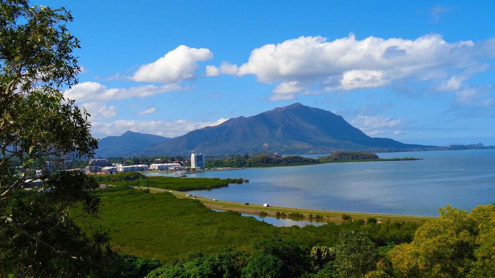 A coastal landscape with a mountain, a body of water, and a cityscape. 4