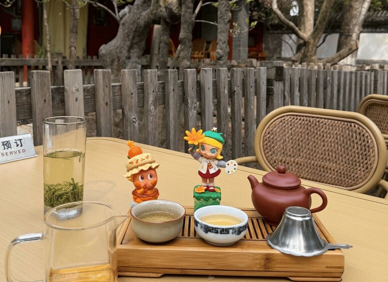 A table with a teapot, cups, and a tea set, with a sign reading 'PREORDER SERVED' in the background. 4