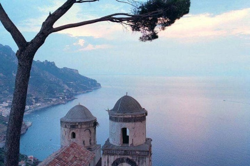 A coastal view with two domed structures and a tree. 1