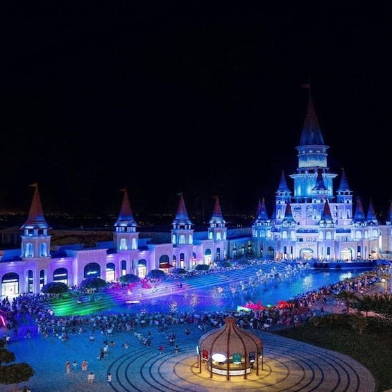 A castle-like building with multiple towers and a large crowd gathered in front. 2