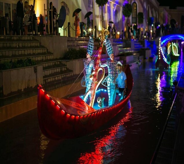 A gondola with illuminated decorations on a canal at night. 5
