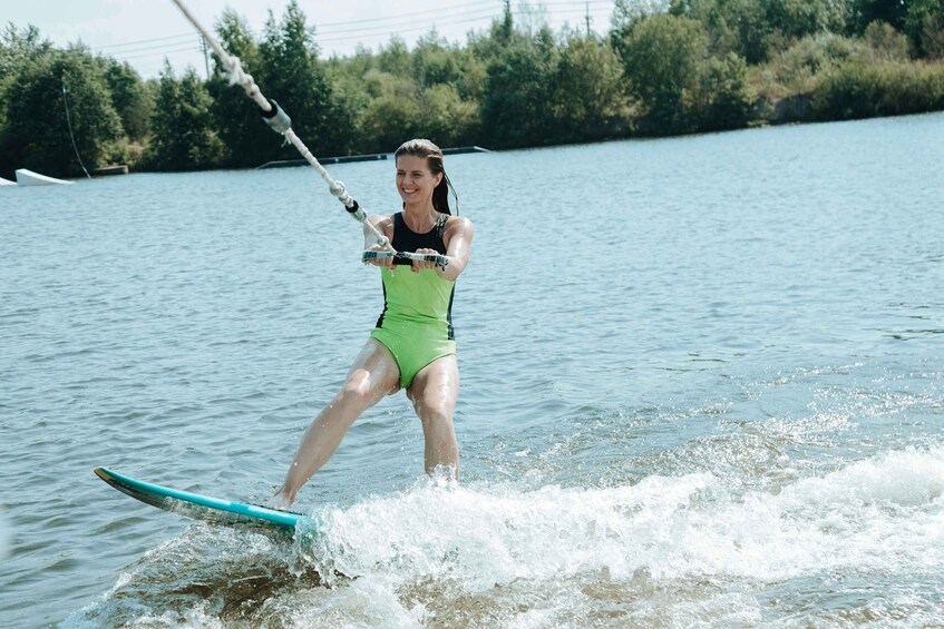A person water skiing on a lake with trees in the background. 3