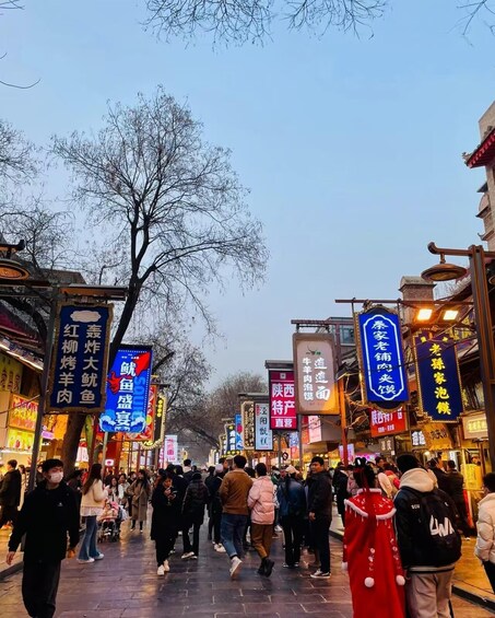 A bustling street lined with traditional buildings and illuminated signs in a foreign language. 5
