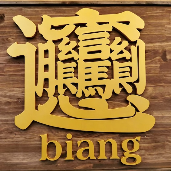 A wooden sign with Chinese characters and the word 'biang' below them. 3