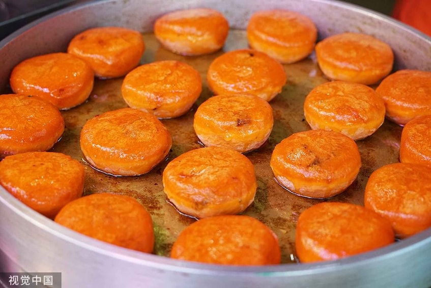 A pan filled with round, golden-brown pastries. 5