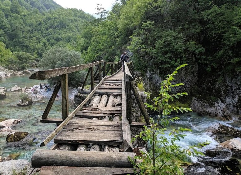 A wooden bridge over a river surrounded by forest. 3