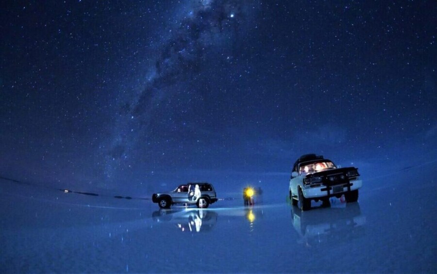 Two vehicles on a reflective surface under a starry sky. 1