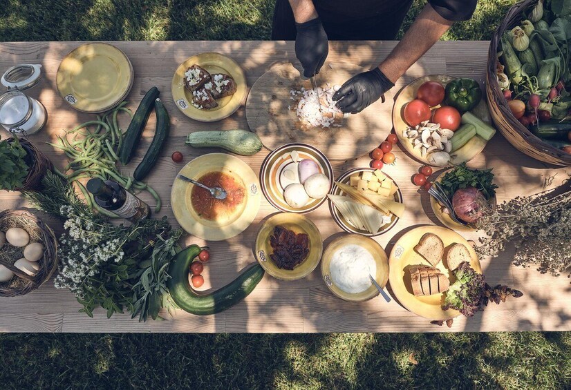 A picnic table with various foods and vegetables spread out. 5