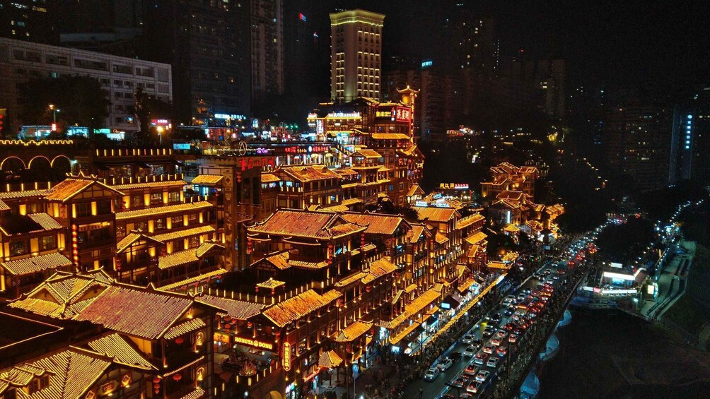 A night view of a traditional Chinese town with illuminated buildings and a busy street. 5