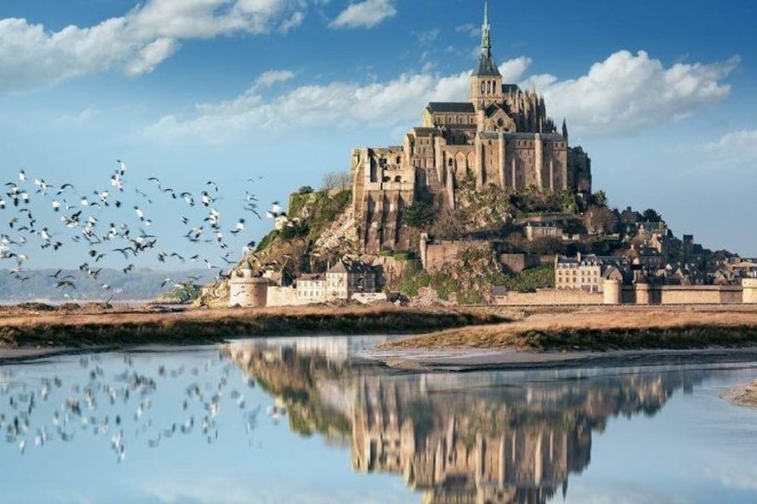 A historic castle on a hill with a river in the foreground reflecting its image. 1