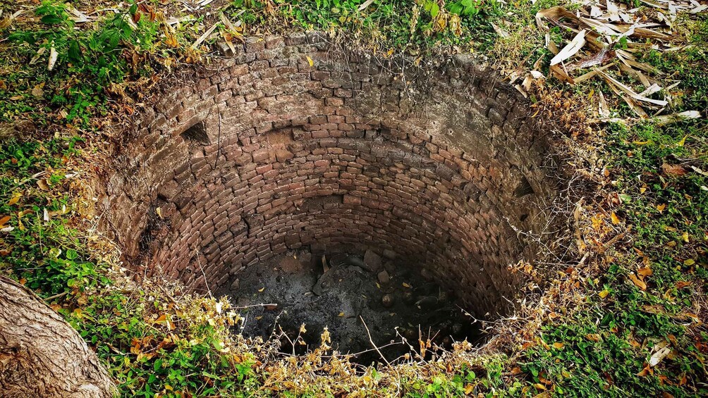 A circular brick structure surrounded by vegetation. 2