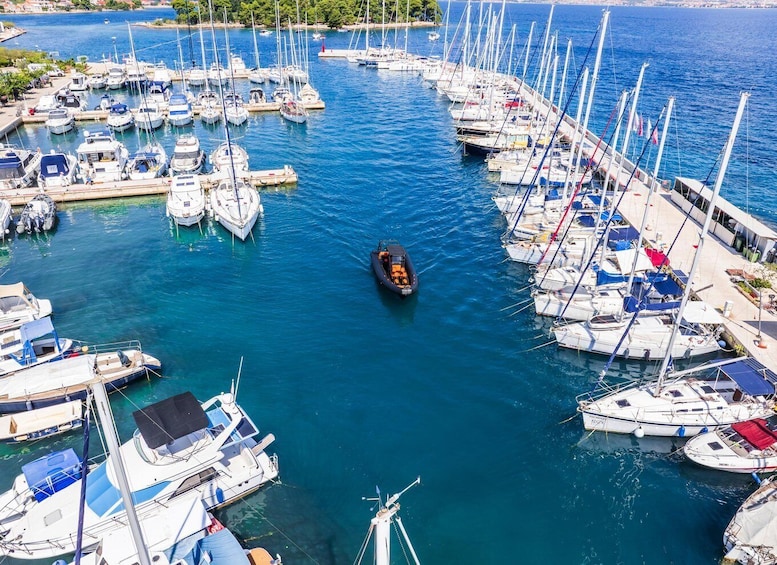A marina with numerous sailboats docked in calm waters. 4