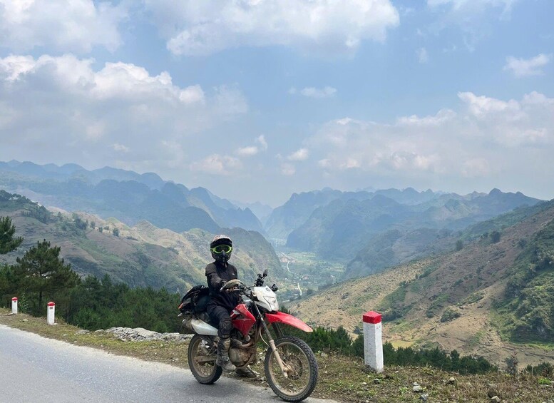 A motorcyclist on a road with a mountainous landscape in the background. 2