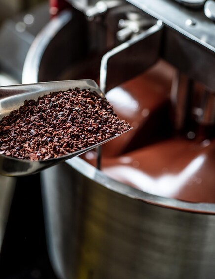 A spoonful of chocolate chips being held over a pot of chocolate. 5