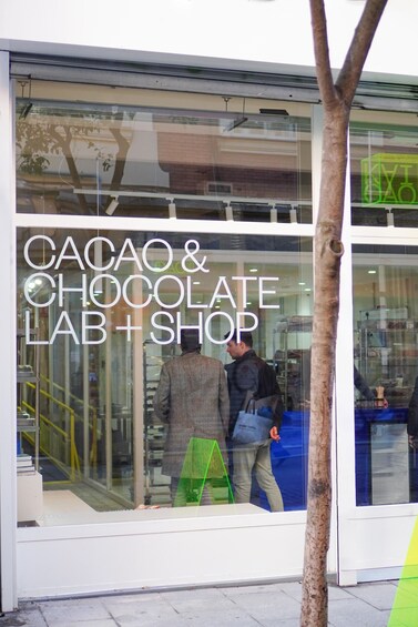 A storefront with a sign reading 'CACAO & CHOCOLATE LAB + SHOP'. 1