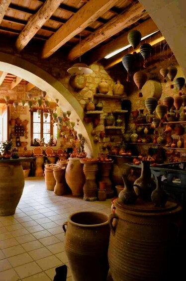 A pottery shop with large ceramic pots and hanging pottery. 4