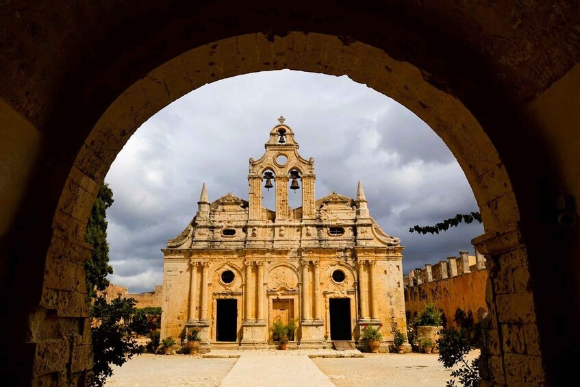A historic church with a bell tower, framed by an archway. 1