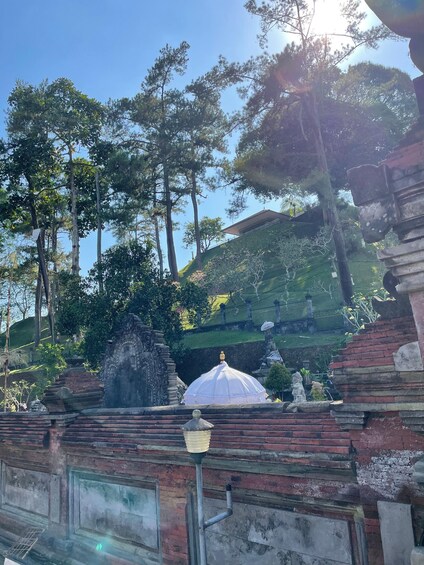 A temple with a white dome, surrounded by trees and a hillside. 3