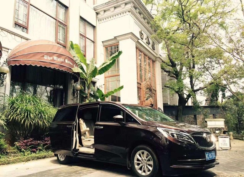 A black minivan parked in front of a building with a brown awning and a sign that reads "The Little House." 5