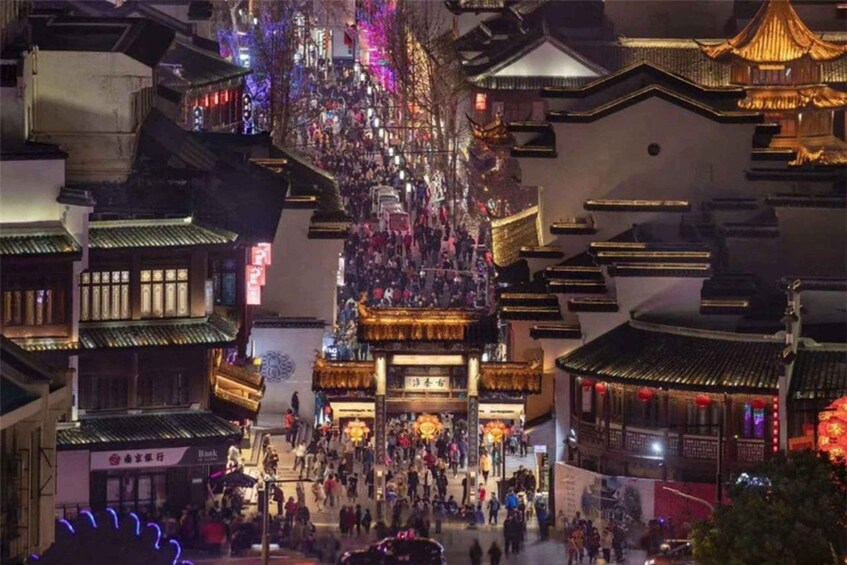 A traditional Chinese street with ornate buildings and a crowd of people. 4