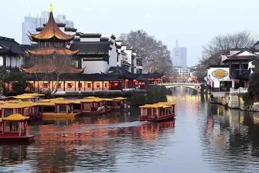 A traditional Chinese water town with ornate buildings and yellow-roofed boats on the water. 2