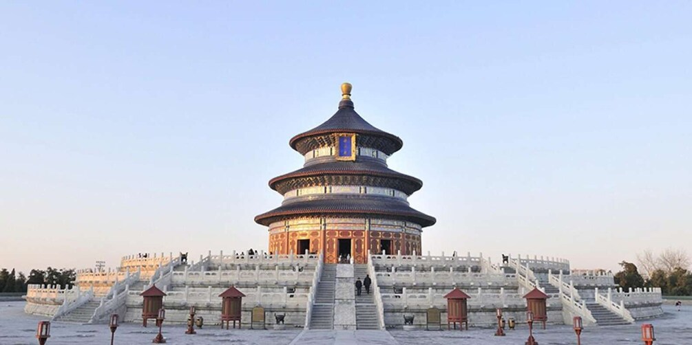 A large, multi-tiered pagoda with a golden roof, surrounded by a stone wall and a series of steps leading up to it. 3