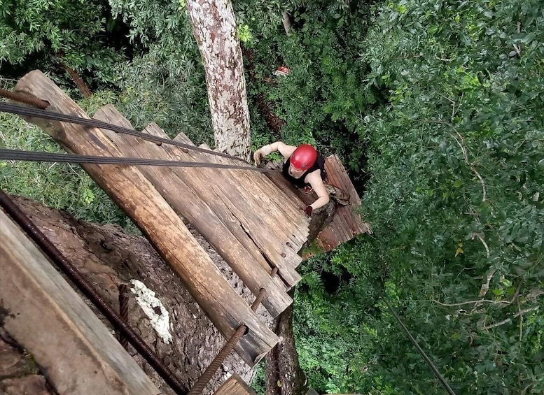 A person climbing a wooden structure in a forested area. 4
