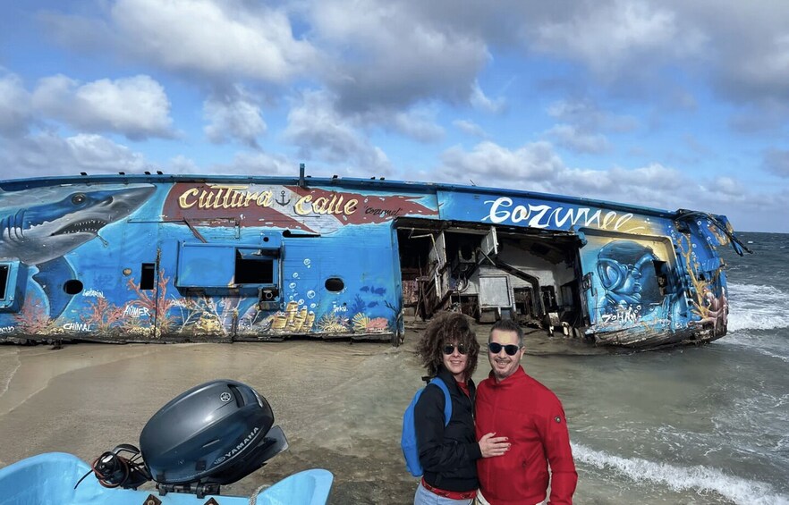 A blue boat with 'Cultura Cafe' and 'Cozumel' written on it, partially submerged in water. 3