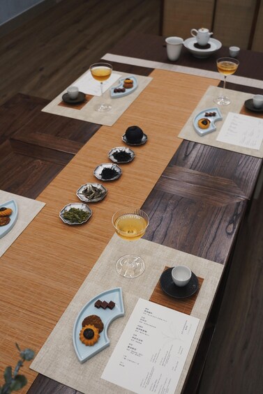 A table with various dishes, tea sets, and a menu. 5